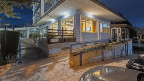 A hotel with a modern design, featuring a well-lit entrance, a visible reception area, and a staircase leading to the entrance. - Azzurro Hotel Residence (L'Aquila)