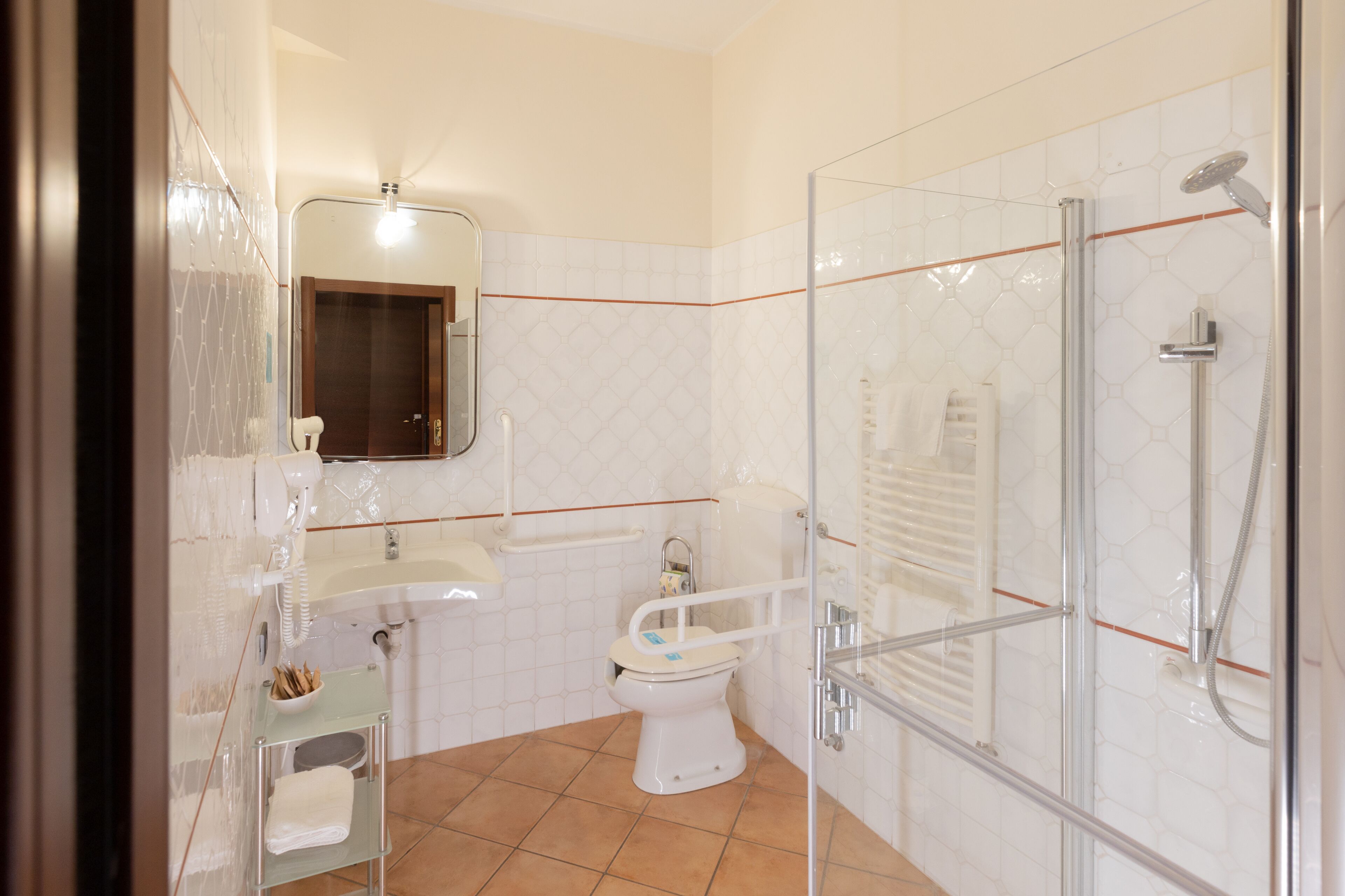 A bathroom with a toilet, sink, and shower area.