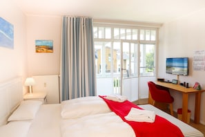 Ein Hotelzimmer mit einem Bett, einem Schreibtisch, einem Stuhl, einem Fernseher und einem Kalender an der Wand.