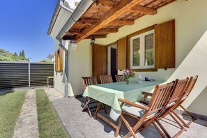 Enjoy al fresco dining under a charming pergola surrounded by a beautiful garden view.