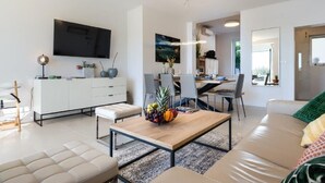 Una sala de estar moderna con un sofá, una mesa de centro y un comedor.