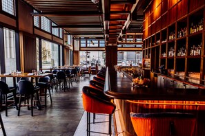 A modern bar with wooden shelves and a long counter. - Surety Hotel, Autograph Collection (Des Moines)
