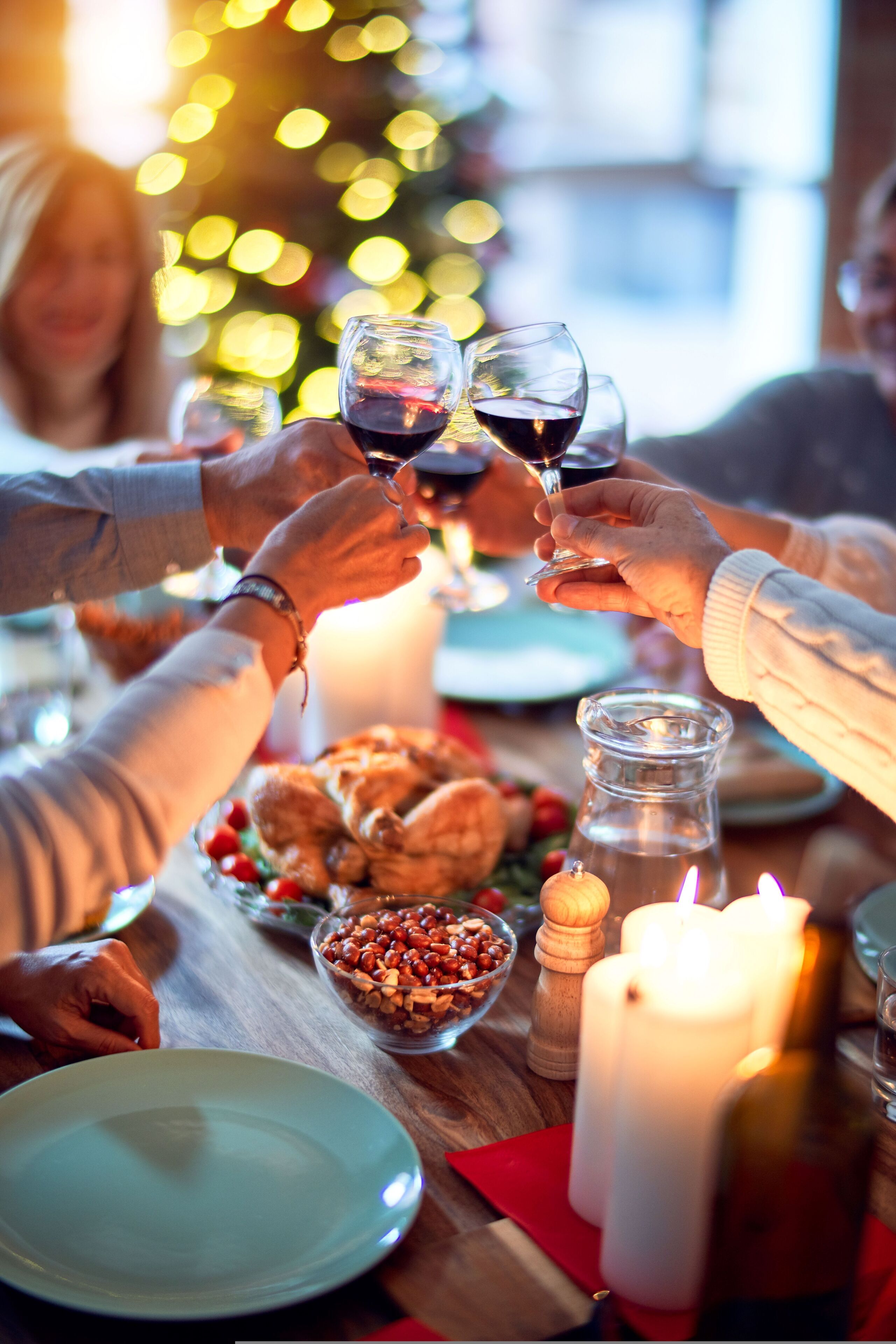 A festive dining setting with a candle, a bottle, and a plate of food.