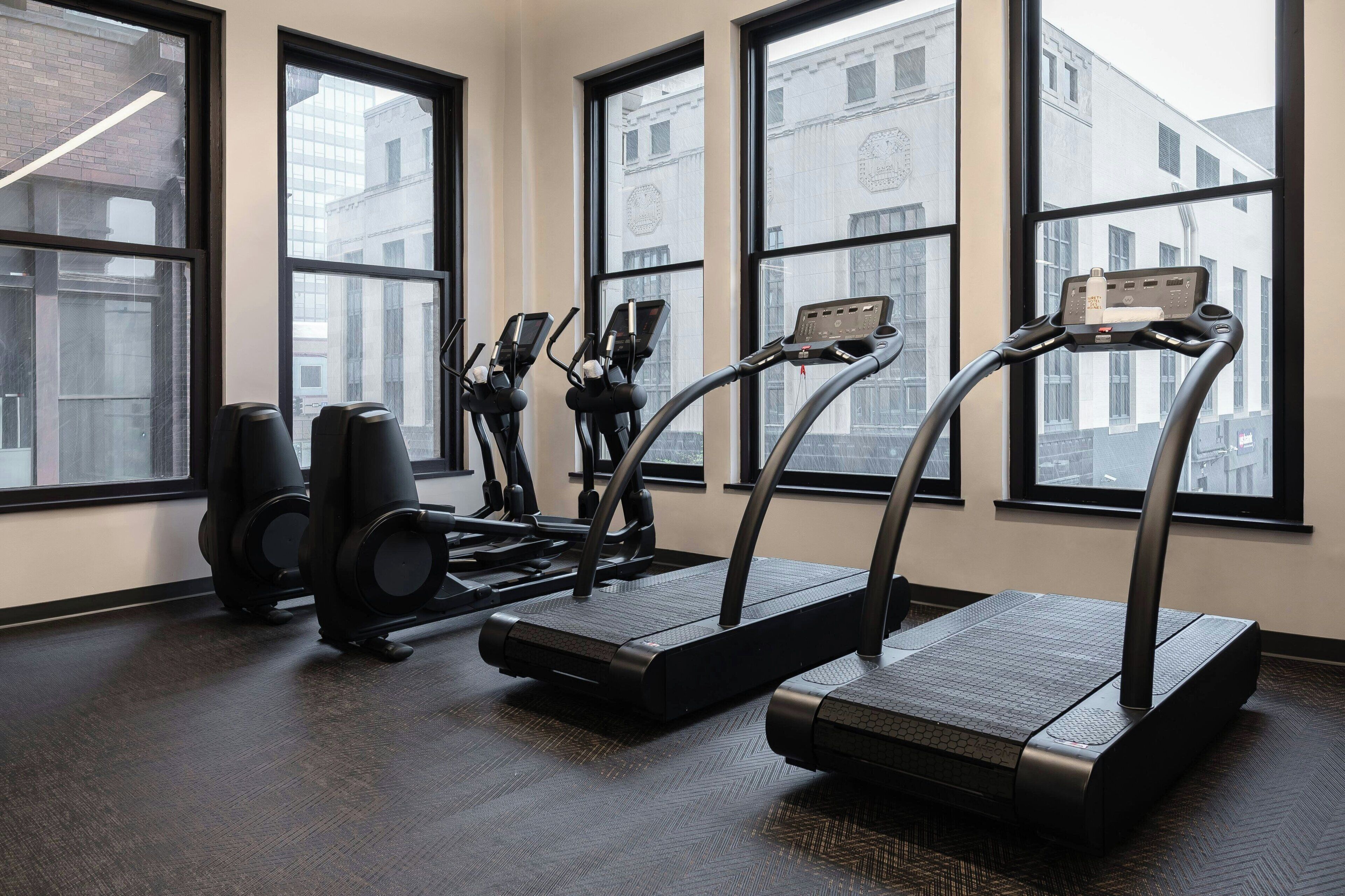 Een sportschool met loopbanden, elliptische trainers en hometrainers.