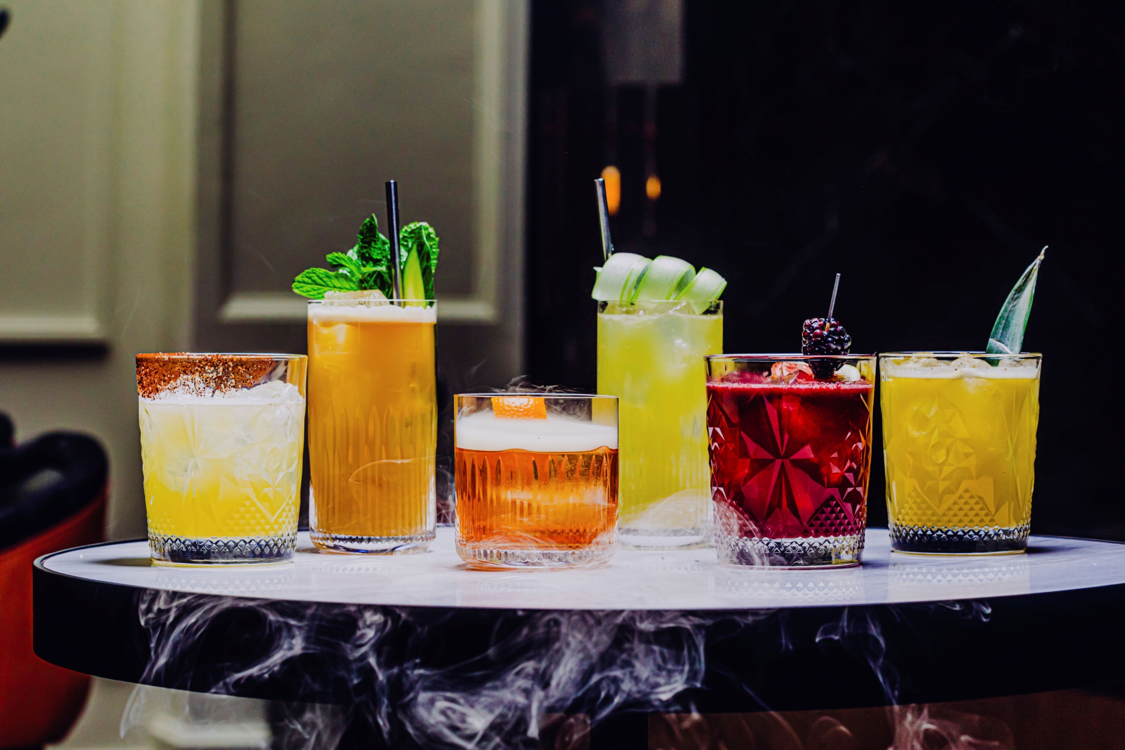 A variety of colorful cocktails on a tray.