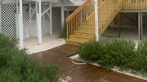 Un bâtiment à deux étages doté d’une terrasse en bois et d’une balustrade blanche.