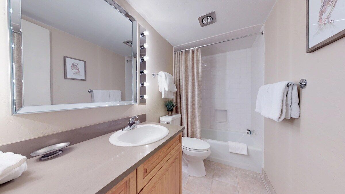 A modern bathroom with a sink, mirror, and toilet.