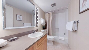 Un baño moderno con lavamanos, espejo e inodoro.
