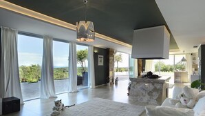 Un salon moderne avec une grande fenêtre, un canapé blanc, un tapis blanc et une statue de tigre.