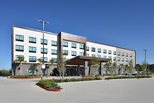 Un hotel moderno con tejado plano, varias ventanas y un acceso cubierto.