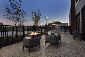 Un patio exterior con asientos, una chimenea y vistas a un cuerpo de agua.