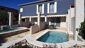 A modern building with a pool area, including a hot tub and a table with chairs. - Beautiful villa 400 meters to beach with 2 pools (Banjole)