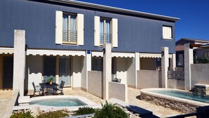A modern building with a pool area, outdoor seating, and a covered patio. - Beautiful villa 400 meters to beach with 2 pools (Banjole)