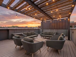 Een terras met wicker meubels en lichtjes.