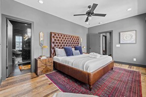 A modern bedroom with a tufted headboard, a large bed, a standing lamp, and a ceiling fan. - Luxury WeHo Home w/ DT Rooftop Views + Nightlife (Nashville)