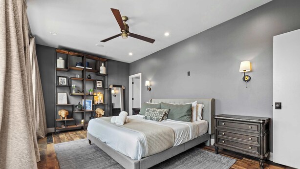 A bedroom with a bed, bedside tables, a dresser, a ceiling fan, and wall-mounted lights. - Two Luxury WeHo Homes w/ Rooftops + 6BR Near DT (Nashville)