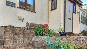 A stone wall with a sign reading "ONE HEATHS YARD".