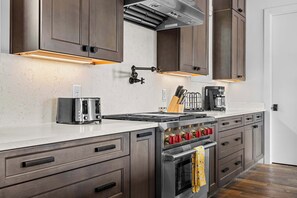 A modern kitchen with a built-in oven, a coffee maker, and a toaster. - Luxe WeHo Gem | Rooftop Views • DT • Nightlife (Nashville)