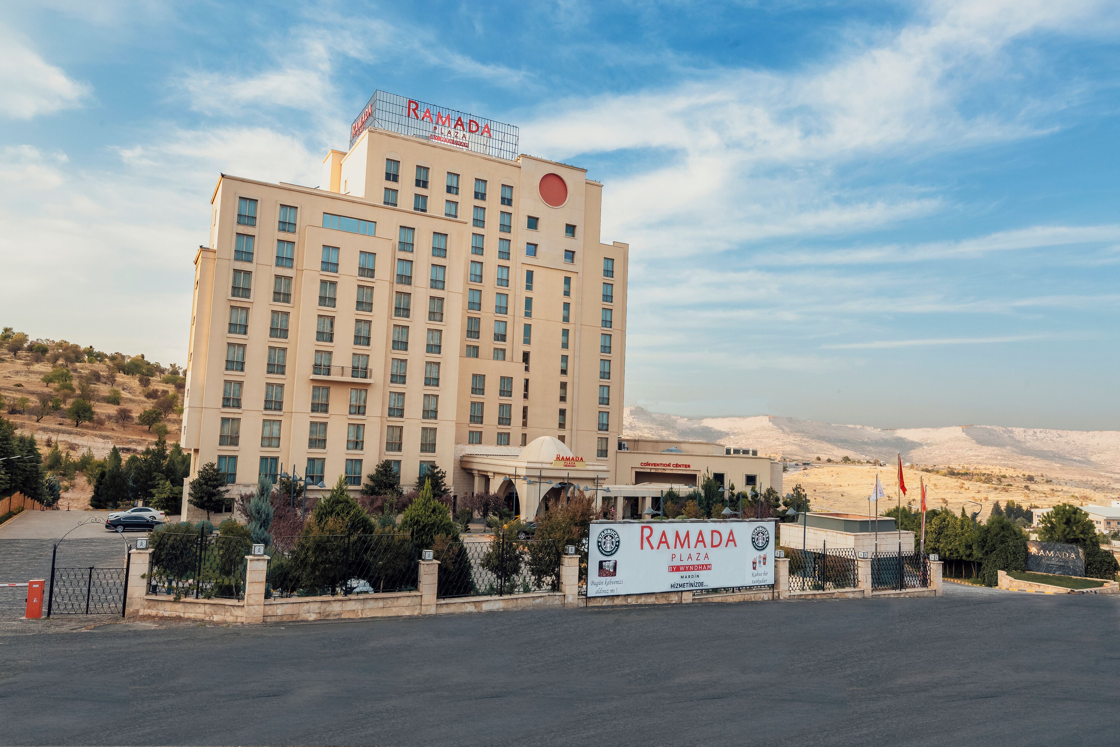 A multi-story hotel with a prominent sign reading 'RAMADA' and 'CONVENTION CENTER' on the facade.