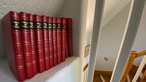 Une rangée de livres rouges portant le titre « HONORÉ DE BALZAC » est posée sur une étagère blanche.