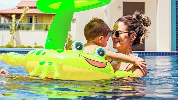 A swimming pool with a child and an adult. - Orquídeas Praia Hotel (Porto Seguro)