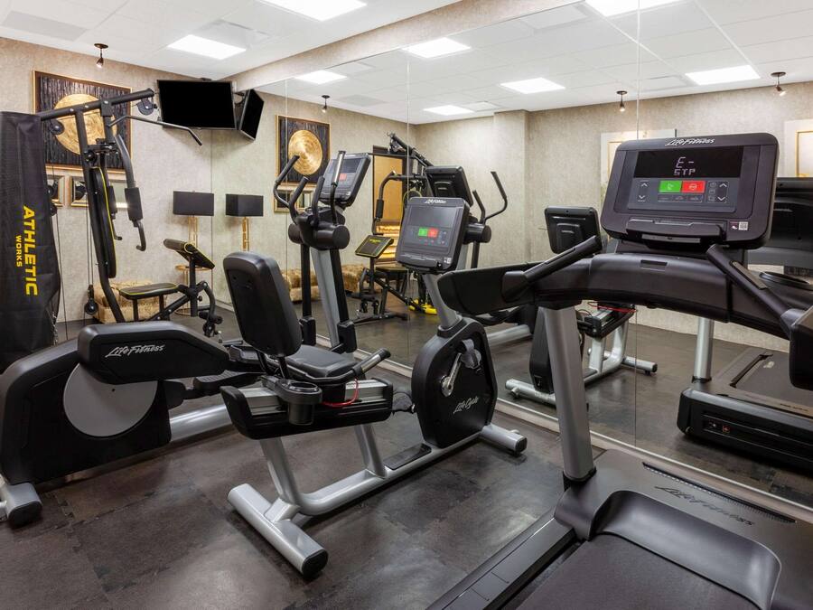 A gym with various exercise equipment, including treadmills, stationary bikes, and weight machines.