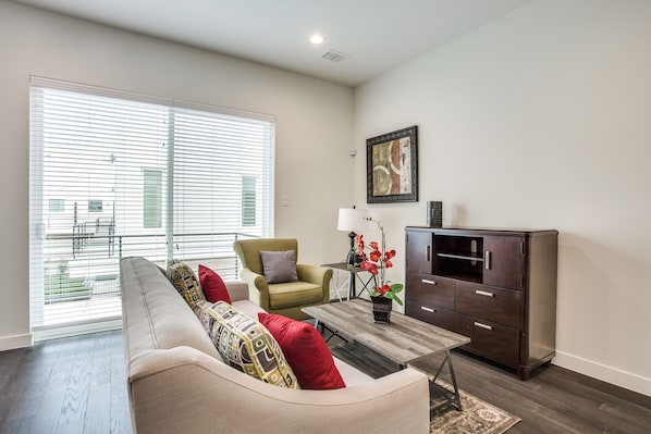 A living room with a sofa, armchair, coffee table, and cabinet.