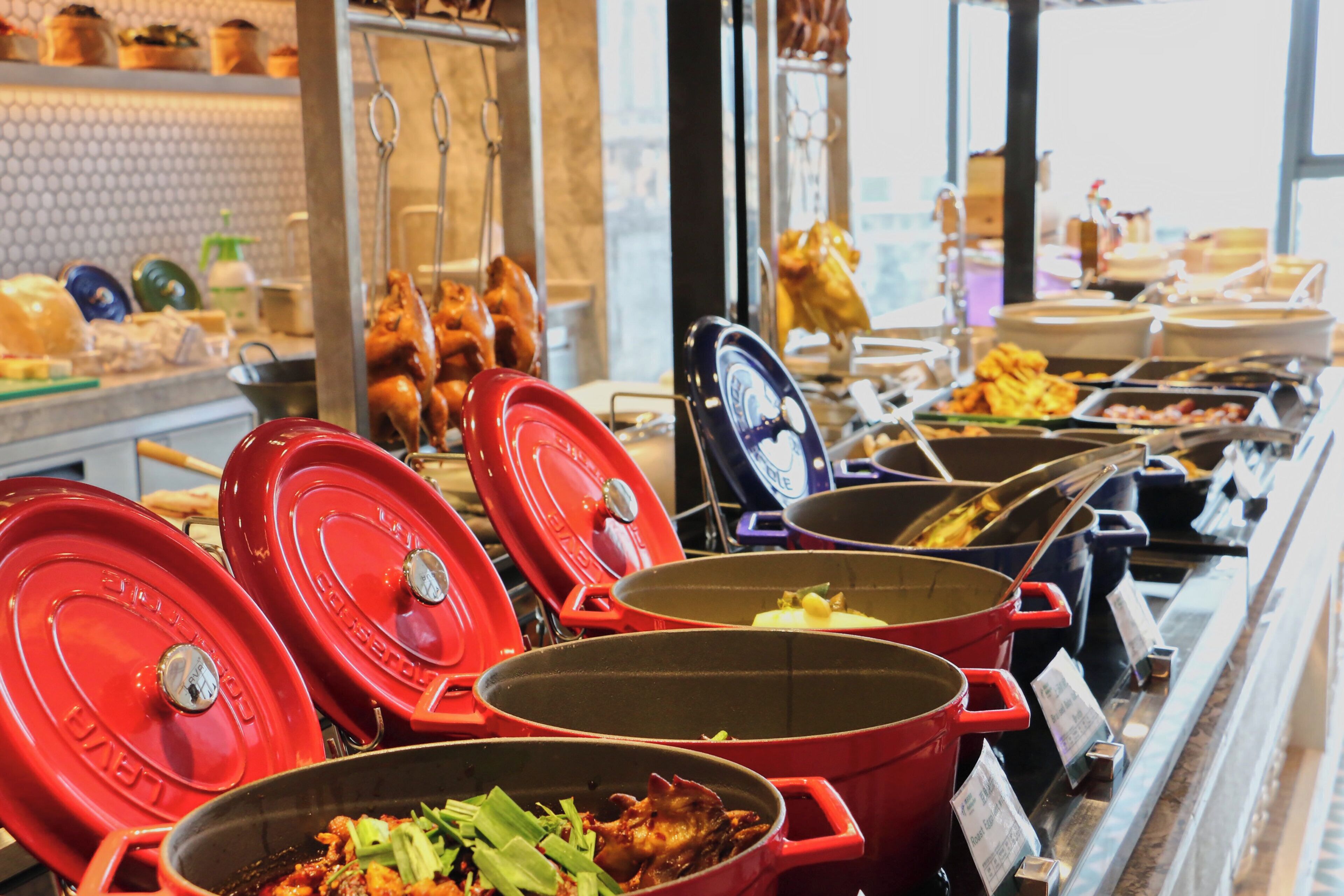 A buffet with various dishes and cooking equipment.