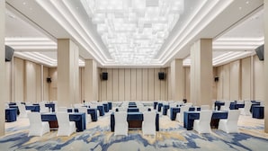 A conference room with rows of tables and chairs, a patterned carpet, and a modern ceiling design. - Holiday Inn Guiyang City Center by IHG (Guiyang)