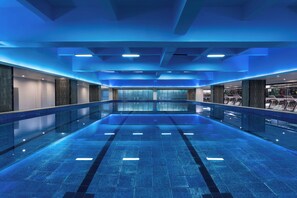 A large indoor swimming pool with a modern design, surrounded by walls with glass panels and a ceiling with recessed lighting. - Holiday Inn Guiyang City Center by IHG (Guiyang)