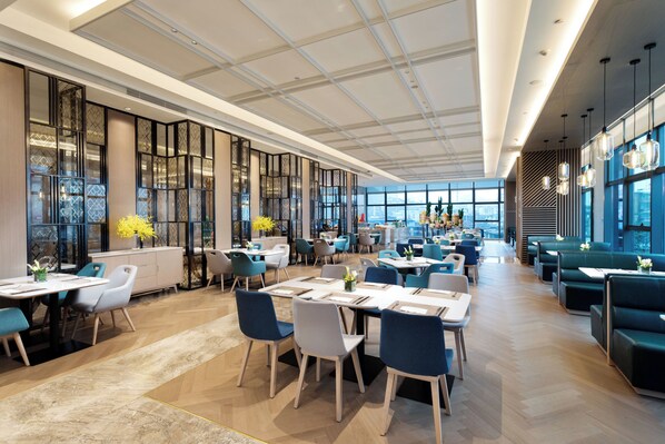 A spacious restaurant with high ceilings, large windows, and modern furniture. - Holiday Inn Guiyang City Center by IHG (Guiyang)