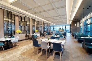 A spacious restaurant with high ceilings, large windows, and modern furniture. - Holiday Inn Guiyang City Center by IHG (Guiyang)