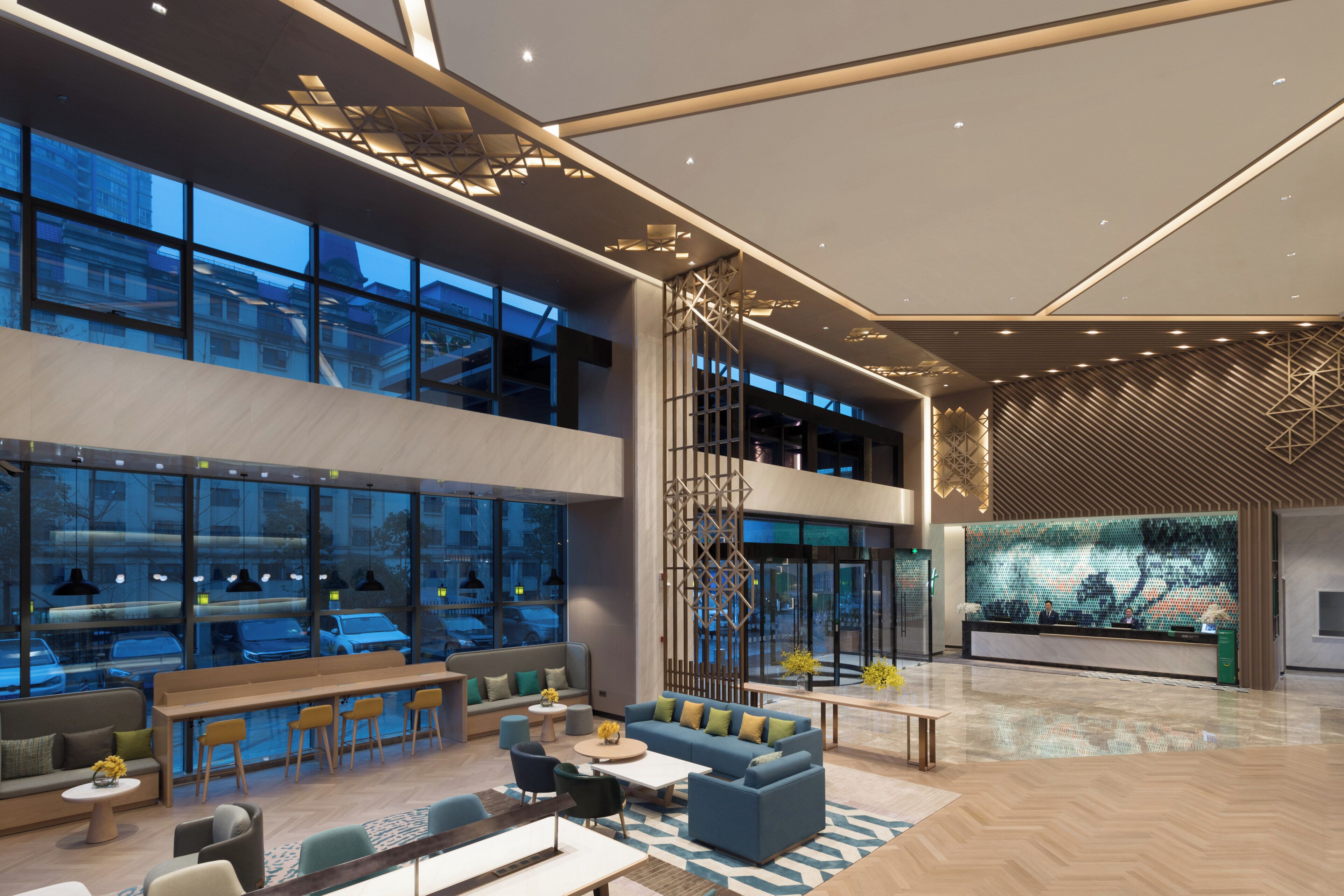 A spacious lobby with a high ceiling, large windows, and a reception desk.
