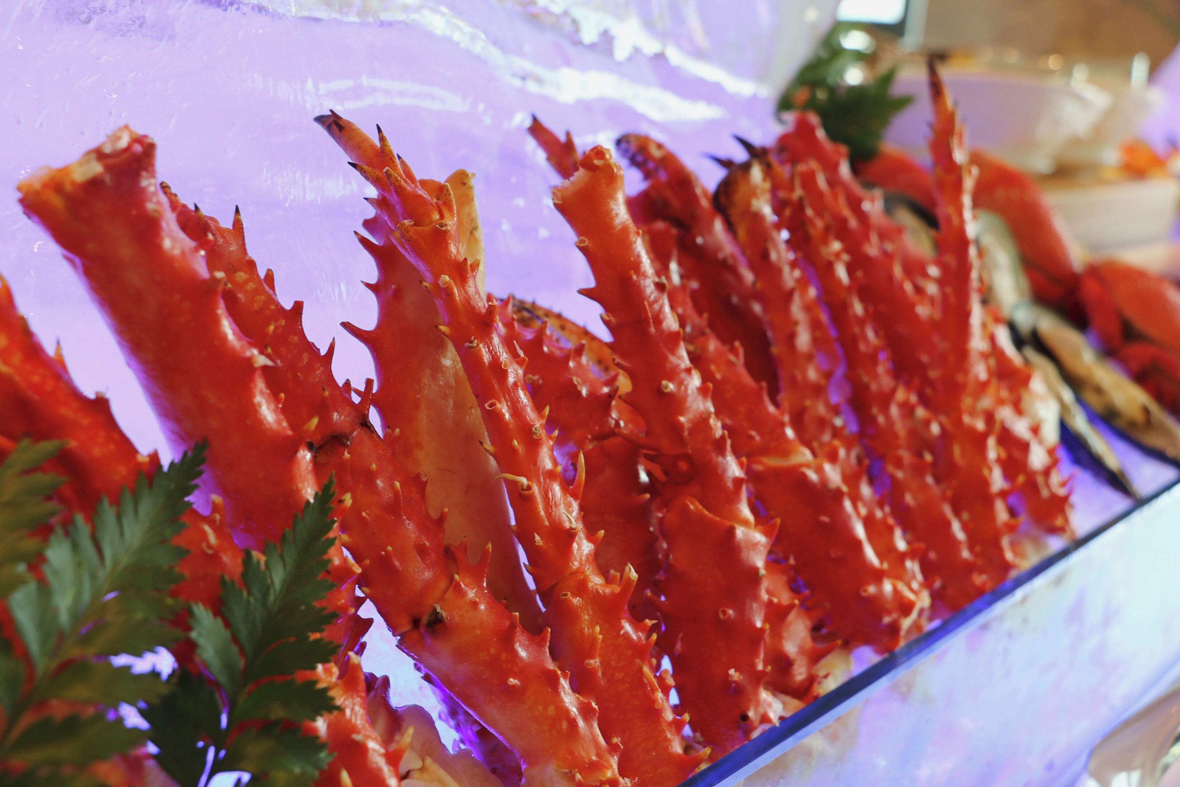 A glass display case containing cooked crab legs.
