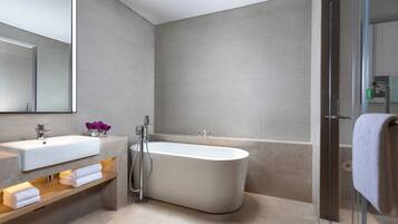 A modern bathroom with a freestanding bathtub, a vanity with a mirror, and a glass shower enclosure.