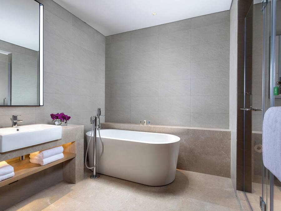 A modern bathroom with a freestanding bathtub, a vanity with a mirror, and a glass shower enclosure.