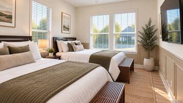 A hotel room with two beds, a ceiling fan, large windows, and a potted plant.