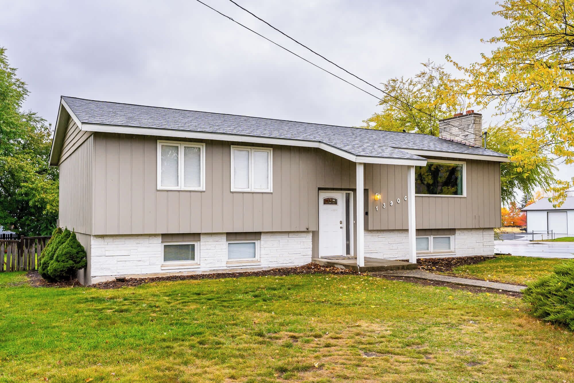 A two-story house with a front porch, a garage, and a small front yard.