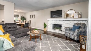 A living room with a fireplace, a dining area, and a sofa.