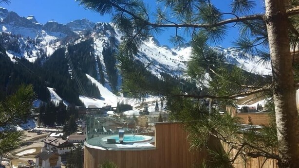 A mountain resort with a pool area, surrounded by snow-covered peaks and pine trees. - Wellness Residence Panorama - Check-in at  Olympia Hotel (Livinallongo del Col di Lana)