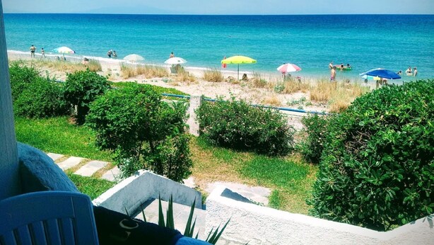 A beach view with umbrellas and people. - House by the sea with amazing view (Skala Fourkas)