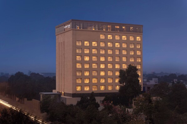 Un grand immeuble d’hôtel, avec de nombreux étages, de grandes fenêtres et un toit plat.