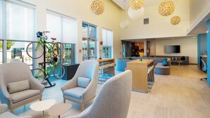 Um interior moderno com área de estar, uma bicicleta e um bar/lounge com televisão.