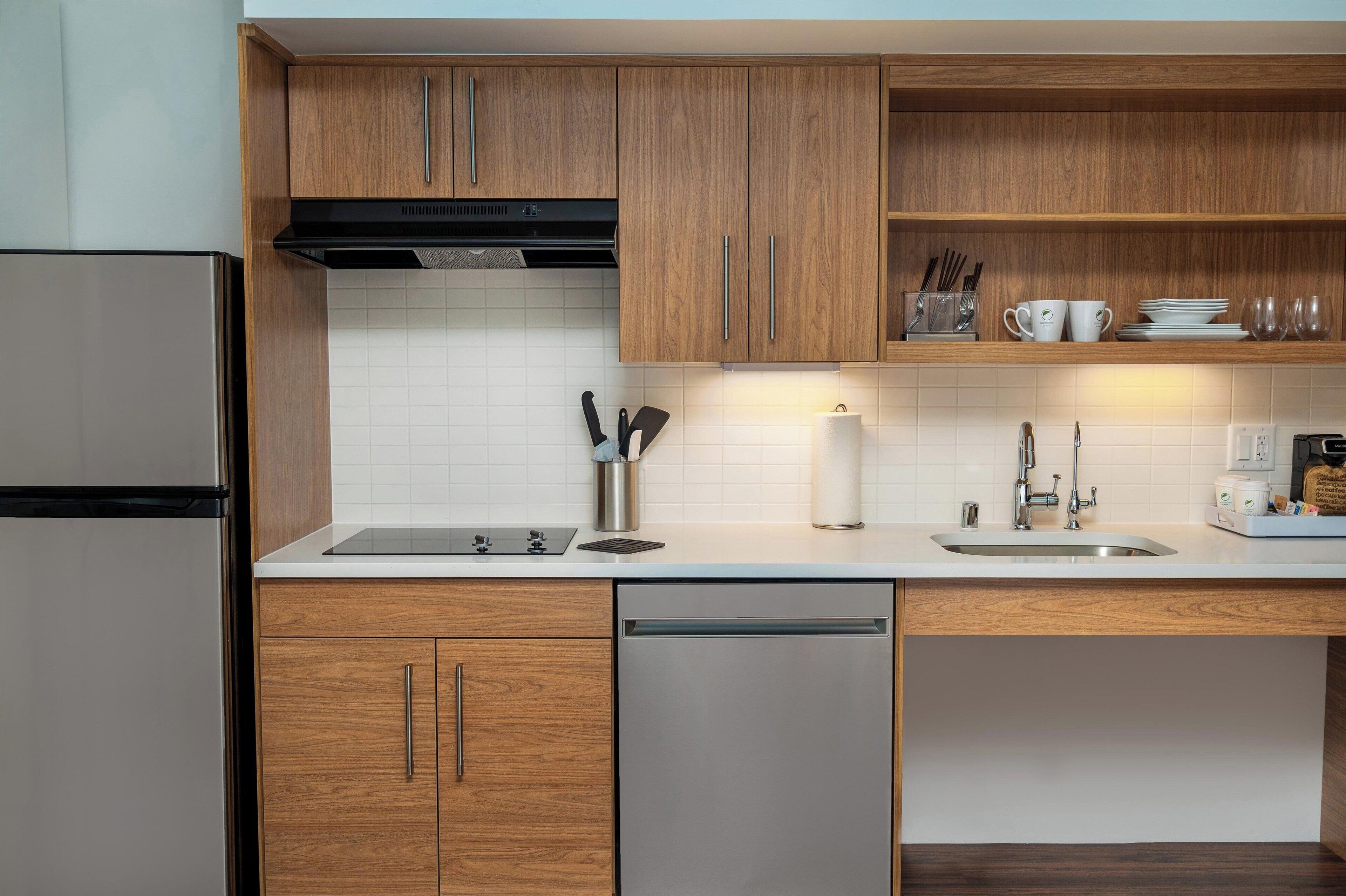 Eine moderne Küche mit Holzschränken, Edelstahlgeräten und einer weißen Küchenzeile.
