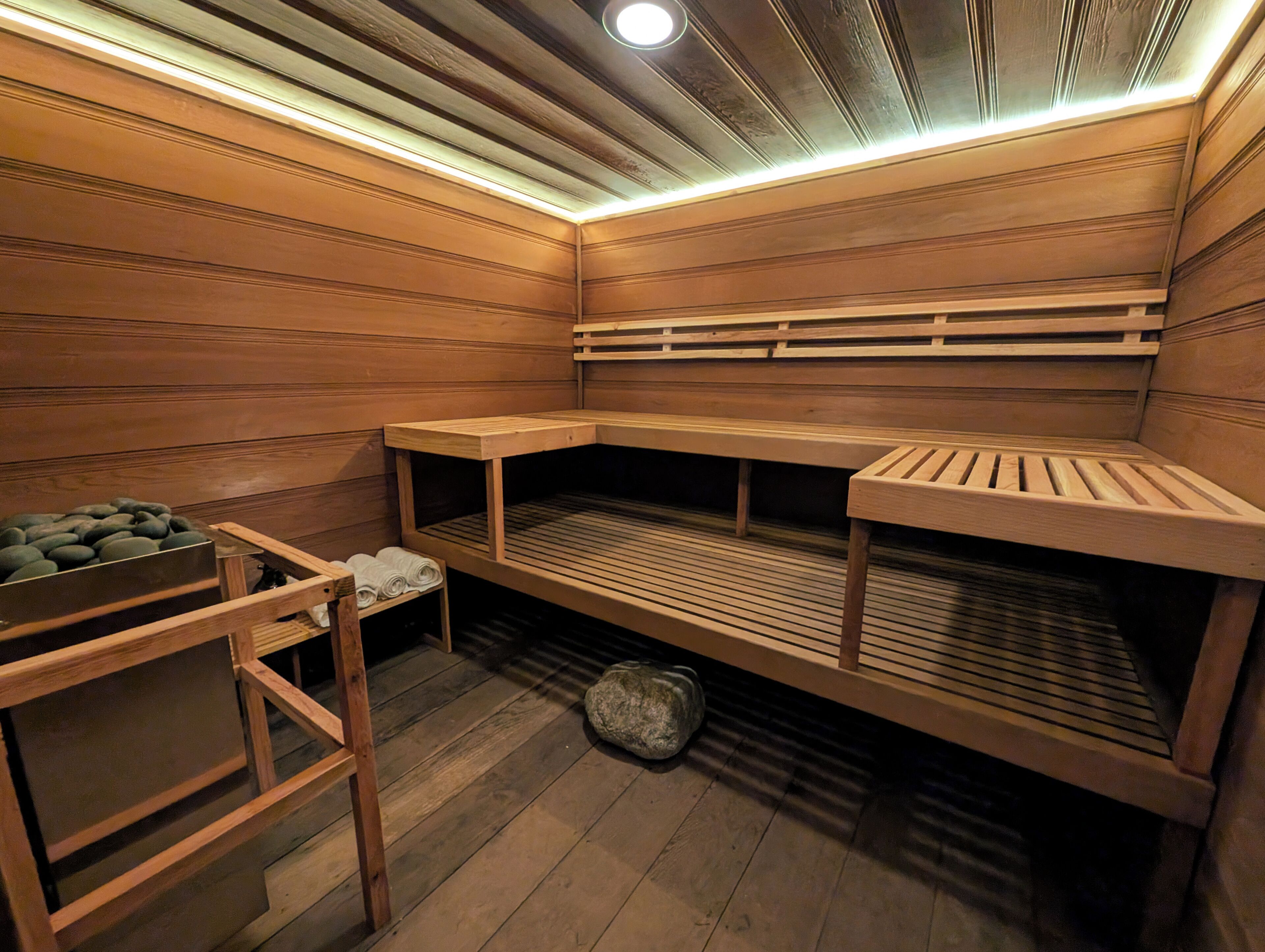 A sauna with wooden benches and a bench with a backrest.
