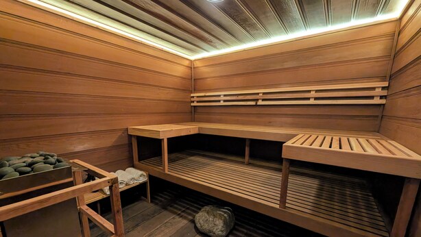 Un sauna avec des bancs en bois et un banc doté d’un dossier.
