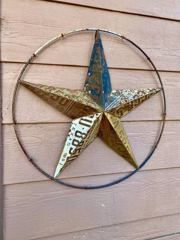 A decorative star made of metal sheets with inscriptions, mounted on a wooden wall.