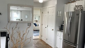 A kitchen with a white countertop, a large refrigerator, and a wooden dining table with jars. - Oceanfront Beach House/ Fall asleep listening to the waves (Scituate)