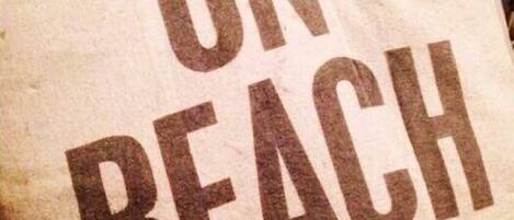 A dog with a pillow that reads "ON BEACH TIME".