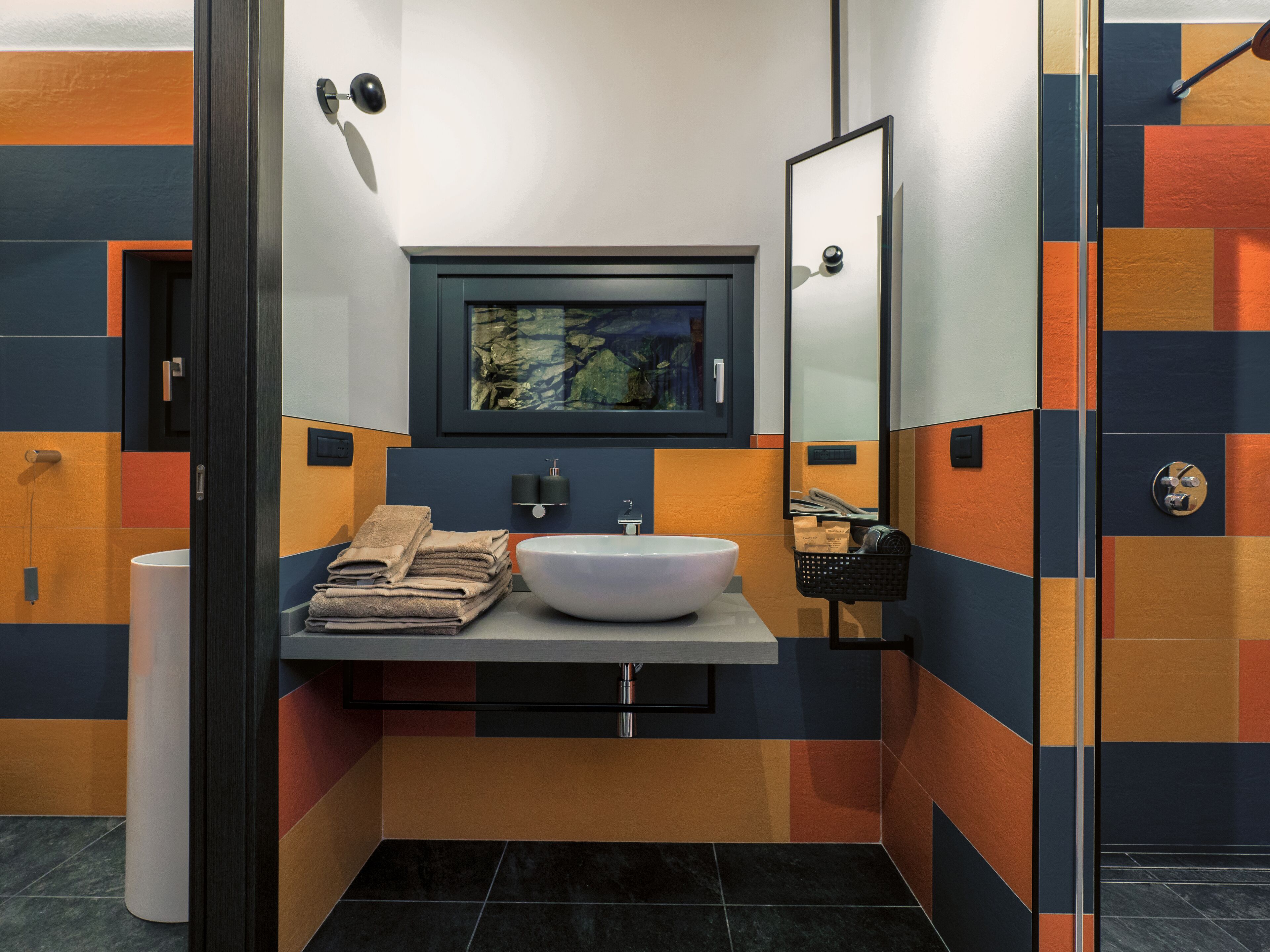 A modern bathroom with a white sink, a mirror, and a towel rack.